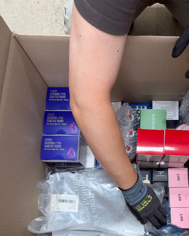 Gloved hands packing the items into one large box