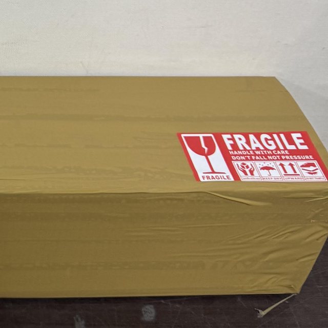 The sealed shipping box with a FRAGILE sticker, ready for FedEx pickup